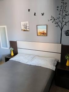 a bedroom with a bed and a tree on the wall at Verde Mar Abricó 2 in Rio das Ostras