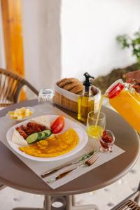 ein Tisch mit einem Teller Essen und einer Flasche Orangensaft in der Unterkunft Vila Violet Berat in Berat + 62 Fotos