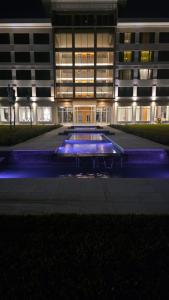 a building with a pool in front of it at night at Azahar Hotel & Spa in San Pedro