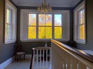 a staircase with a large window and a chandelier at Blackhill Woods Retreat in Abbeyleix