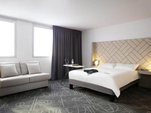 a hotel room with a bed and a couch at Ibis Styles Paris Massena Olympiades in Paris +35 photos