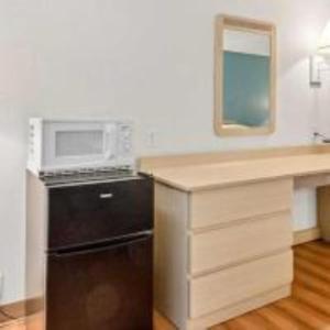 a kitchen with a microwave and a black refrigerator at Big Springs Inn in Big Springs