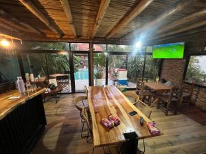 a large wooden table in a restaurant with a pool at Arenas Lodge Hotel in Esquina