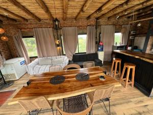 a living room with a wooden table and chairs at Arenas Lodge Hotel in Esquina