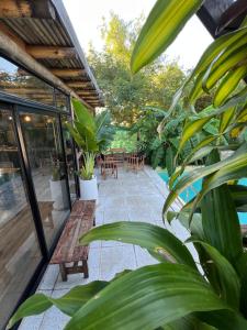 a patio with tables and chairs and plants at Arenas Lodge Hotel in Esquina