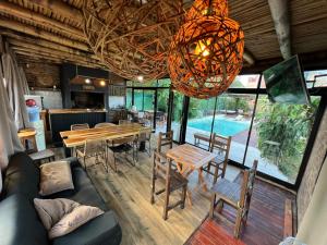 a living room with a table and chairs and a chandelier at Arenas Lodge Hotel in Esquina