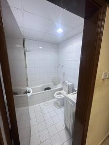 a bathroom with a toilet and a bath tub at 1 BHK Flat in Sharjah