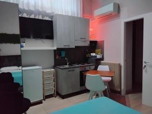 a small kitchen with white cabinets and a table and chairs at Suite House in Sora