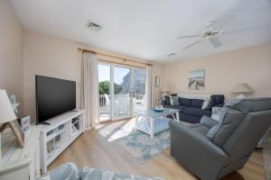 a living room with a couch and a tv at 4218 - The Scotts' SandBar in Duck