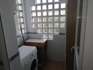 a small bathroom with a washing machine and a window at BLUE Dreams in Mijas Costa