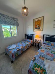 a bedroom with two beds and a window at BLUE Dreams in Mijas Costa +15 photos