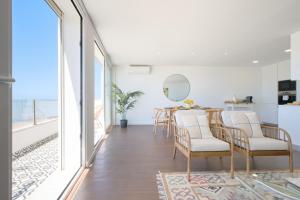 a dining room with white walls and a table and chairs at Dreamy Sea View Balcony in Algés
