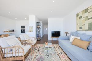 a living room with a blue couch and chairs at Dreamy Sea View Balcony in Algés