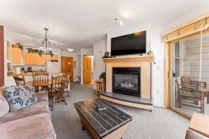a living room with a fireplace and a dining room at Silver Mill #8222 in Keystone