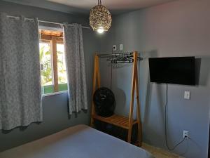 a bedroom with a bed and a flat screen tv at Verde Mar Abricó 2 in Rio das Ostras