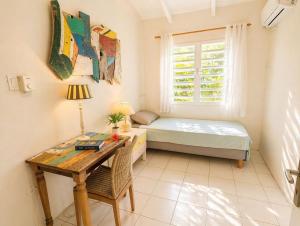 a bedroom with a desk and a bed and a window at 30 Kas Di Mi Sonjo in Kralendijk +13 photos