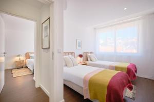 a bedroom with two beds and a window at Dreamy Sea View Balcony in Algés