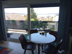 a table and chairs in a room with a large window at Luxor4 in Kaštela