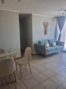 a living room with a blue couch and a table and chairs at Dpto santa rosa in Ovalle +1 photo