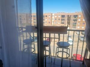 a balcony with three stools and a table on a balcony at Dpto santa rosa in Ovalle