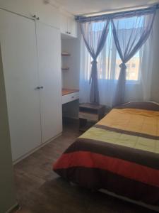 a bedroom with a bed and a window with curtains at Dpto santa rosa in Ovalle