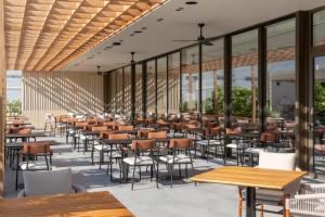 a restaurant with tables and chairs and windows at The Nines in Ayia Napa