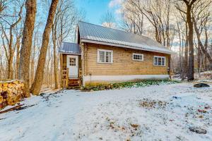 a log cabin in the woods in the snow at Log Ski Lodge in Wilmington