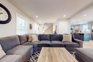 a living room with a couch and a clock on the wall at Modern Mountain Homestead in Dover