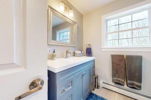 a bathroom with a blue sink and a mirror at Modern Mountain Homestead in Dover +70 photos