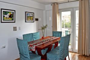 a dining room with a table and blue chairs at Depamia in Huaraz