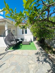 a patio with a hammock and a table and chairs at Grandpa’s cottage in Nea Makri