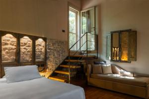 a bedroom with a bed and a staircase and a couch at Borgo Antichi Orti Assisi in Assisi