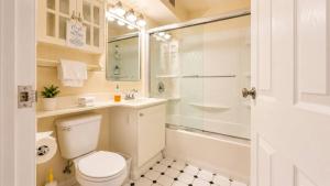 a white bathroom with a toilet and a shower at Downtown 1 BR Condo near Convention Center in Seattle