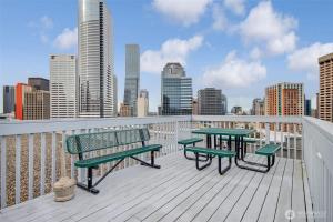 a balcony with benches and tables on a city skyline at Downtown 1 BR Condo near Convention Center in Seattle