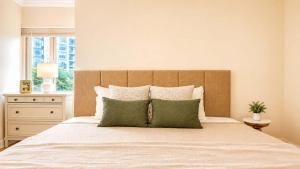 a bedroom with a large bed with two green pillows at Downtown 1 BR Condo near Convention Center in Seattle +28 photos