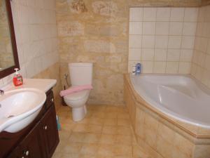 a bathroom with a tub and a toilet and a sink at Villa Aloni in Margarítai