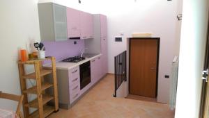 a kitchen with white cabinets and a stove top oven at Appartamento Perito in Perito +16 photos