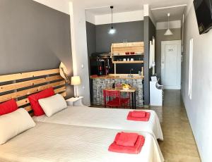 two beds in a small room with a kitchen at Eleana Apartments in Hersonissos