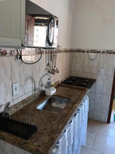 a kitchen counter with a sink and a stove at Verde Mar Abricó 2 in Rio das Ostras