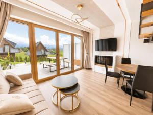 a living room with a couch and a table at Golden Trio Villas in Ząb