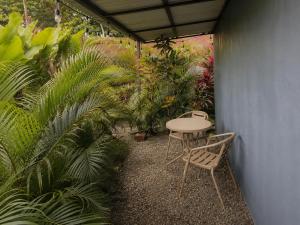 a patio with a table and chairs and plants at IkI Volcán Arenal #2 in Fortuna