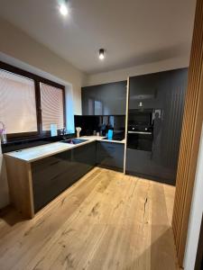 a kitchen with black walls and a wooden floor at Studio apartment in Slezská Ostrava