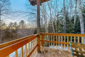 a porch with two chairs and a view of the woods at The Loft at Pine Rock in Weston