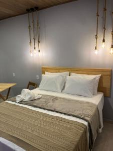 a bedroom with a large bed with white pillows at Pousada Angelim in Santo Amaro