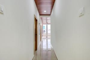 an empty hallway with white walls and a wooden ceiling at Super Townhouse Badangpet Crossway Hyderabad Formerly Balapur in Surūrnagar