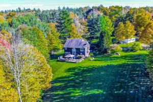 an aerial view of a blue house in the woods at Whistling Peak in Wilmington