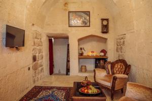 a living room with a tv and a table with fruit at Gazel Cave House in Ürgüp