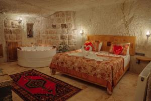 a bedroom with a bed and a bath tub at Gazel Cave House in Ürgüp
