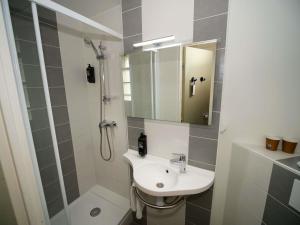 a bathroom with a sink and a shower with a mirror at ibis budget Blois Centre in Blois +107 photos