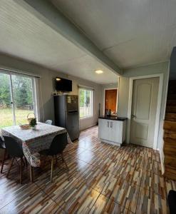 a living room with a table and a kitchen at Sendero de Luna in Valdivia +10 photos